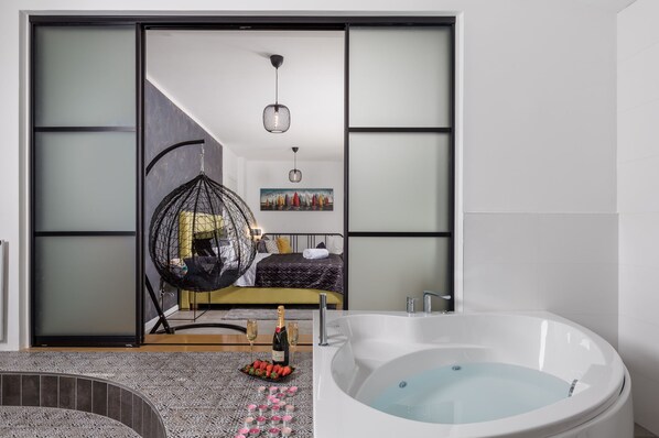 A modern bathroom with a large bathtub, a hanging chair, and a bed with a cityscape painting. - Casa Mills, luxury 4 bedrooms house near Opatija (Poljane)