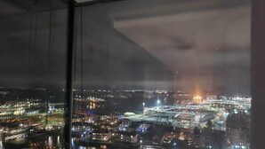 A nighttime cityscape viewed from a high-rise building with a large glass window. - Stunning 3-bed, 3-bath Apartment in Southampton (Southampton)