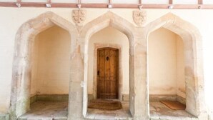 A stone archway with a wooden door, leading to a narrow passageway. - Orchardleigh Castle West, Orchardleigh Estate (Lullington)
