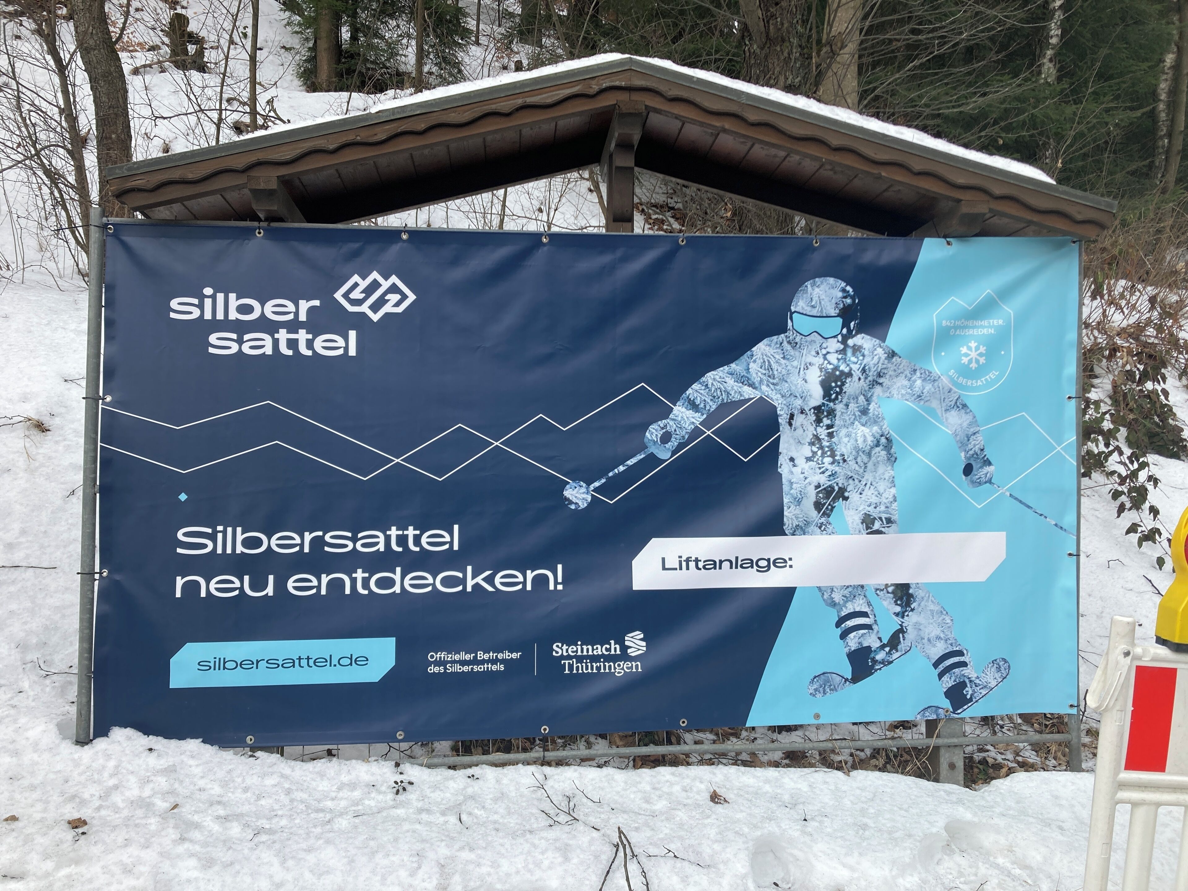 Ein Banner wirbt für Silbersattel mit einer Grafik eines Snowboarders, einem Weblink und dem Schriftzug 'Silbersattel neu entdeckt!'.
