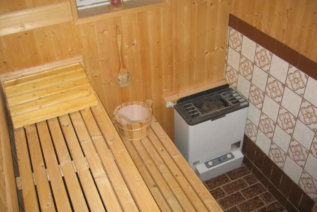 A small, compact kitchen with a wooden countertop, a gas stove, and a tiled backsplash.