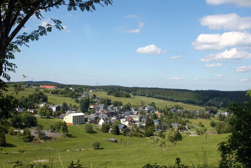 Een landelijk dorpje met huizen en gebouwen verspreid over groene velden.