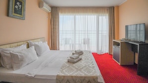 A hotel room with a bed, a desk with a television, and a window with curtains. - Hotel Romantic (Constanta)