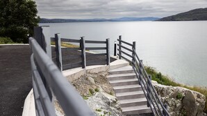 A staircase leading to a viewpoint overlooking a body of water with distant mountains. -  Pierside Apartments Deluxe Accommodation (Portsalon)