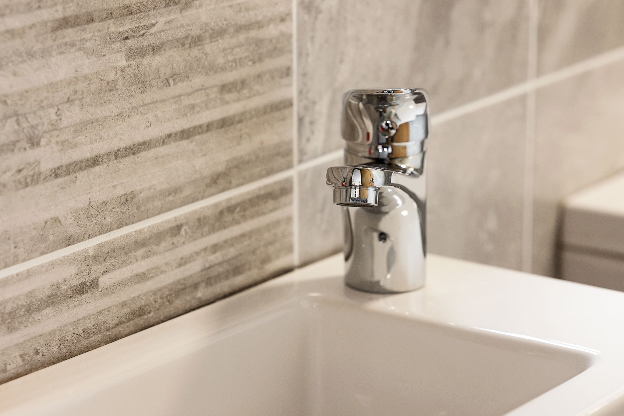 A bathroom with a modern sink and a chrome faucet.