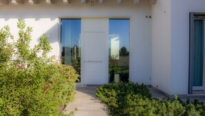 A modern building with a white facade, large glass doors, and a small entryway. - Ca' Belvedere B&B (Silea)
