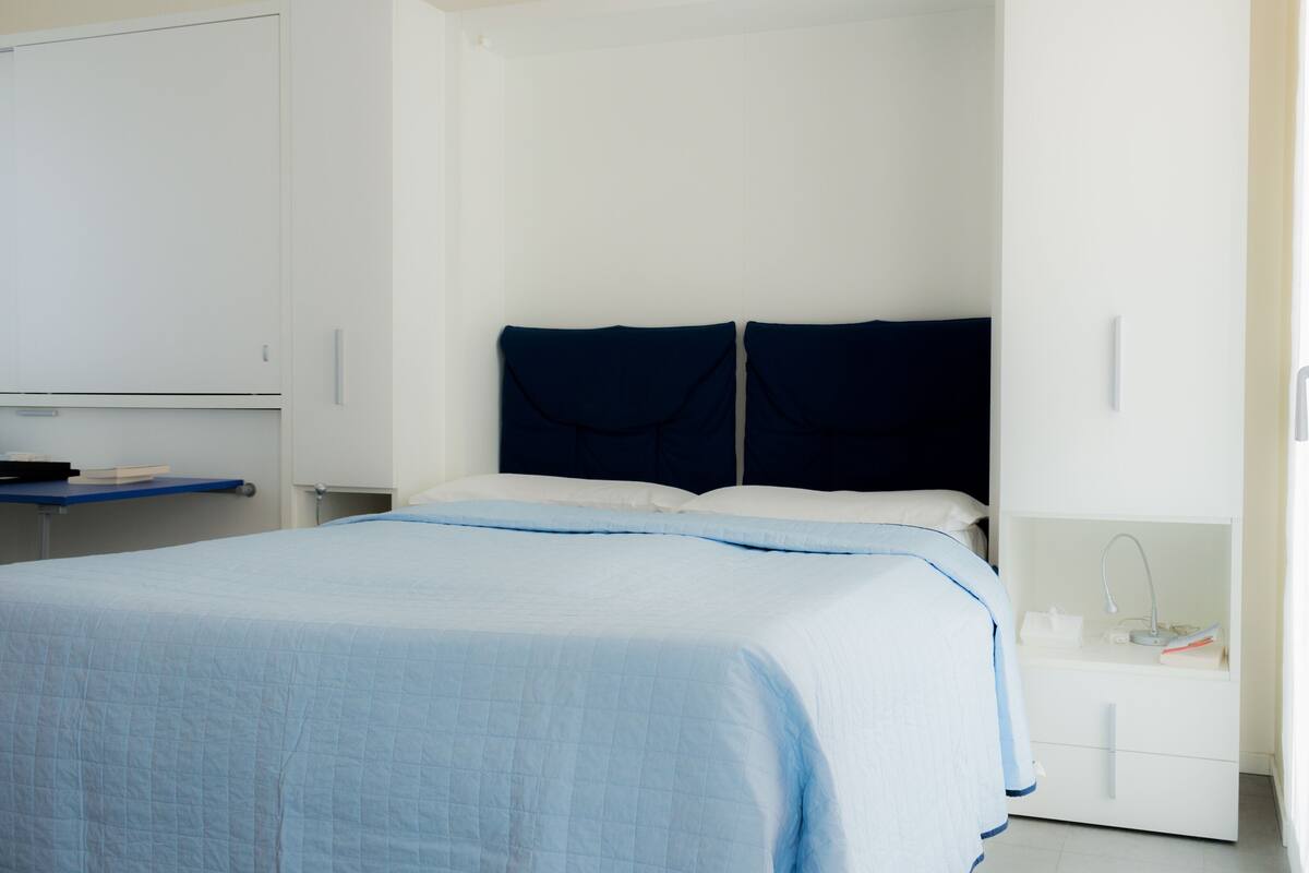 Un dormitorio con cama, escritorio y armario.