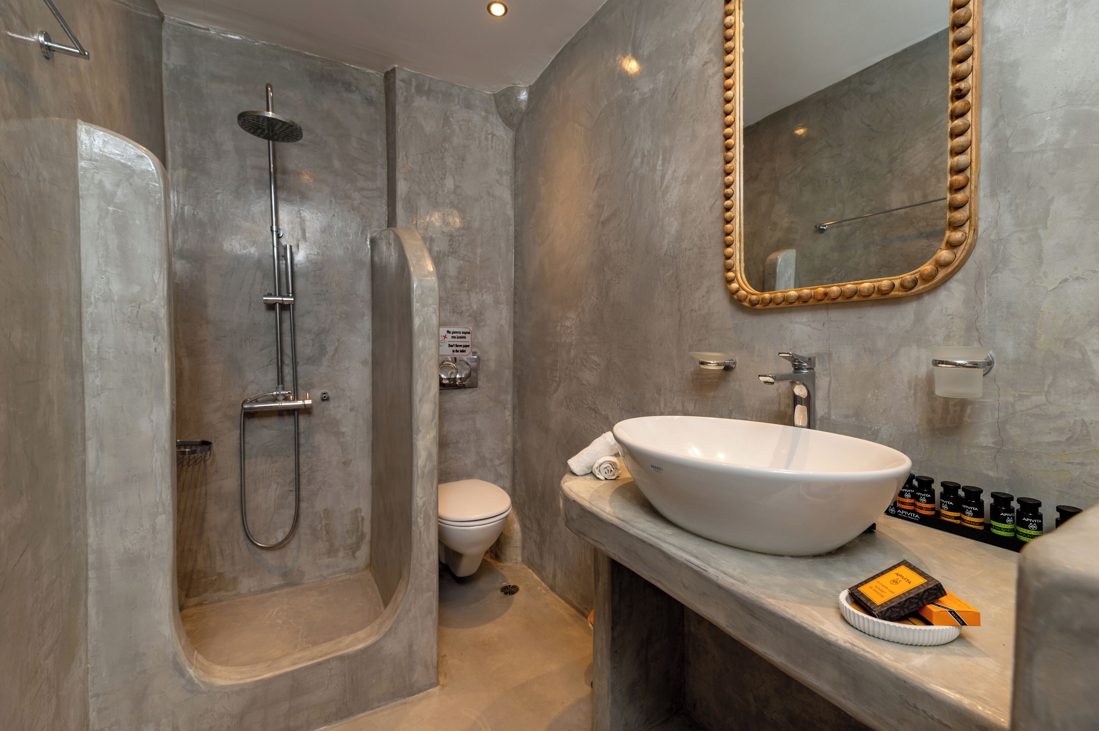 Un baño moderno con una bañera independiente, un espejo grande y un lavabo blanco.