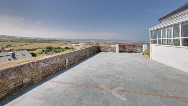 A spacious outdoor patio with a stone wall and a view of the countryside. - Studio with sea view, parking, and pets allowed in La Hague (La Hague)