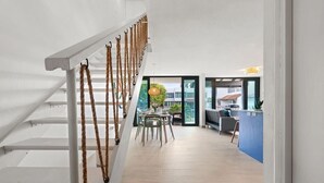 Ein modernes Interieur mit Treppe, Essbereich und Blick ins Freie.