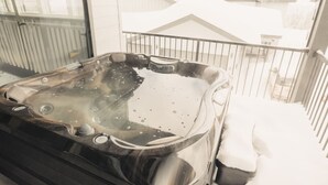 A hot tub on a balcony with snow on the railing. - Brand New Ski in/out + Hot Tub!. (Big White)