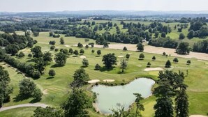 A golf course with multiple holes, a pond, and surrounding wooded areas. - The Bell Tower, Orchardleigh Estate (Frome)