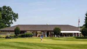 Un terrain de golf avec un bâtiment en arrière-plan.