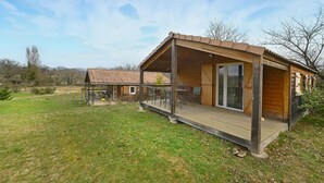 A wooden cabin with a covered porch, a dining area, and a sliding glass door. - Lovely home in Barjac with outdoor swimming pool (Barjac)