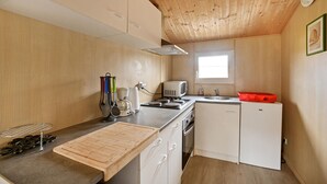 A compact kitchen with wooden walls, a window, a microwave, a sink, and a small refrigerator. - Lovely home in Barjac with outdoor swimming pool (Barjac)