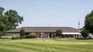 A golf course with a clubhouse in the background.