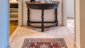 A hallway with a dark wooden console table, a mirror, and a patterned rug. - Modern Apartment Sant Orsola by Wonderful Italy (Bologna)