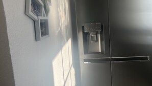 A modern kitchen with a black refrigerator and a water dispenser. - 3 Zimmer Ferienwohnung, Schwarzwald, Nationalpark in der Nähe,haustierfreundlich (Baiersbronn)