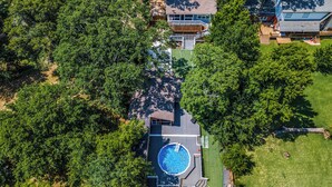 An aerial view of a house with a swimming pool surrounded by trees, a deck, and a covered patio area. - Waterfront Retreat w/ Dock on Lake Tawakoni! (Quinlan)