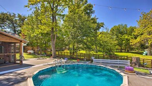 A backyard with a swimming pool, wooden deck, and a fenced area with trees. - Waterfront Retreat w/ Dock on Lake Tawakoni! (Quinlan)