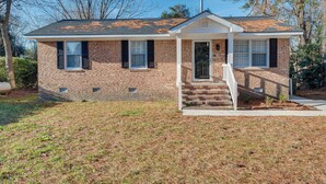 A single-story brick house with a front porch, a small front yard, and a clear sky. - Cozy North Carolina Retreat Near Fishing & Boating (Washington)