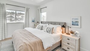 A bedroom with a bed, bedside tables, a ceiling fan, and a window with curtains. - Downtown Winter Park Condo w/ Free Bus to Ski Base (Winter Park)