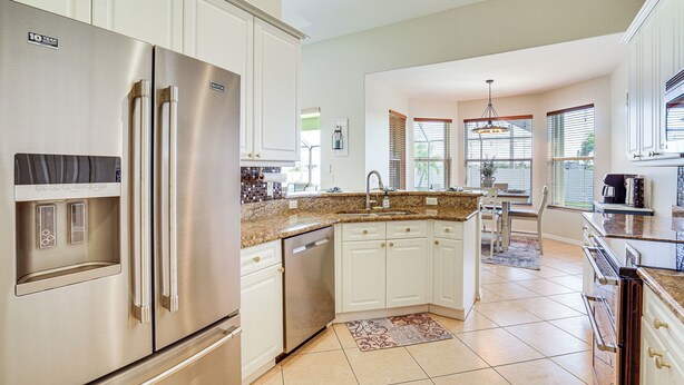 A modern kitchen with stainless steel appliances, white cabinetry, and a granite countertop. - Cozy Cape Coral Home: 8 Mi to Marina! (Cape Coral)