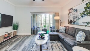 A modern living room with a grey sofa, a white coffee table, and a ceiling fan.
