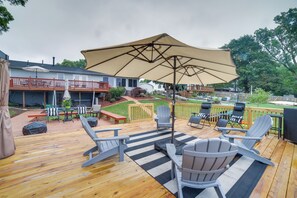 Una terraza con mobiliario exterior, incluyendo sillas y una mesa, bajo un gran paraguas.