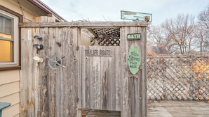 Una struttura in legno rustica con un cartello che indica “TOILET BOATS” e un altro cartello che segnala un “BATHROOM”.