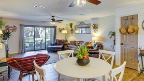 A spacious living room with a dining area, a ceiling fan, and a view to the outside. - Walk to Beach: PCB Condo w/ Oceanfront Pool Access (Panama City Beach)