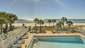 A pool area with lounge chairs, a pool, and a view of the beach and ocean. - Walk to Beach: PCB Condo w/ Oceanfront Pool Access (Panama City Beach)