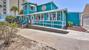 A turquoise building with a sign reading "Coco Beach Inn." It features a covered porch with steps leading to the entrance. - Walk to Beach: PCB Condo w/ Oceanfront Pool Access (Panama City Beach)