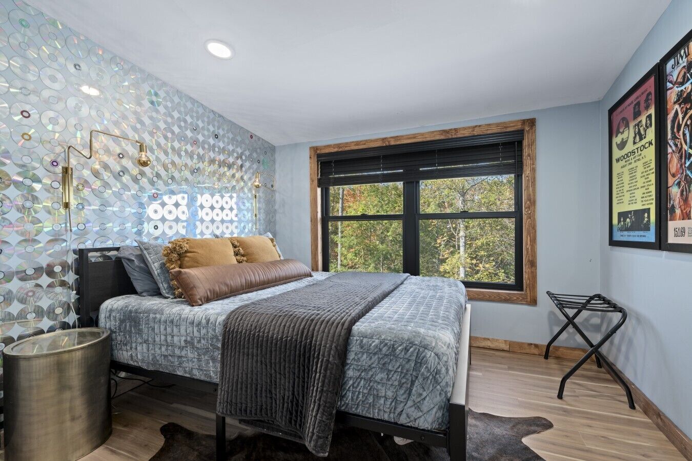 Quarto com cama, janela e parede com padrão circular.