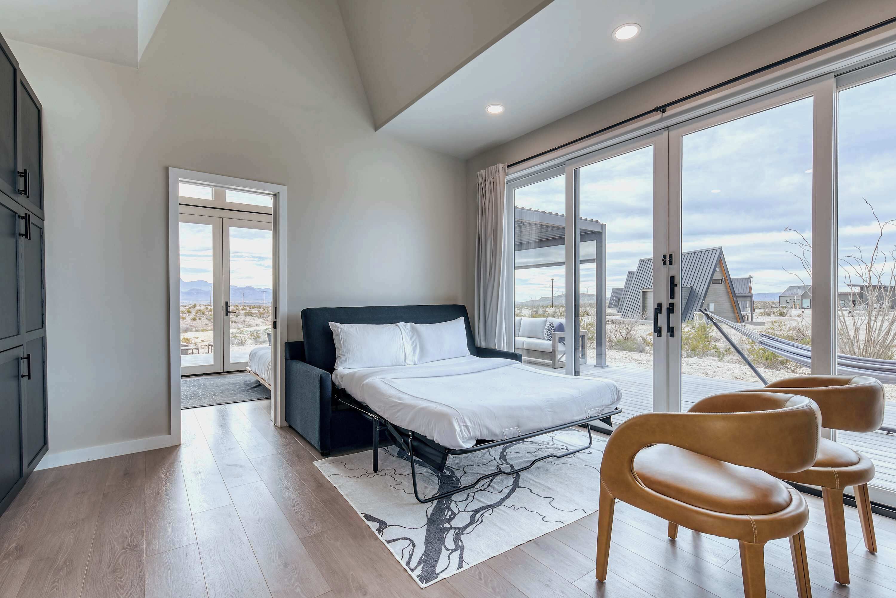 Une chambre à coucher moderne, avec un lit, une grande fenêtre et une vue sur l’extérieur.