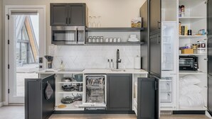 A modern kitchen with built-in appliances, a dishwasher, and a pantry. - Stardust Big Bend Luxury A-Frame#9 with a fab view (Terlingua)