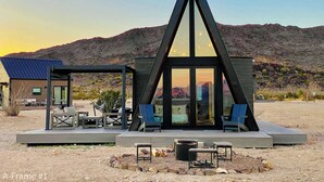 A modern, triangular-shaped building with a deck and outdoor seating area. - Stardust Big Bend Luxury A-Frame#10 with fab view (Terlingua)