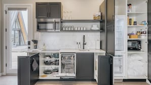 Une cuisine moderne dotée d’appareils électroménagers intégrés, d’un lave-vaisselle et d’un garde-manger.