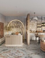 Zona de recepción de hotel con diseño moderno, que incluye un mostrador de recepción, un cartel en la pared, un área de bar con estantes llenos de botellas y un espacio de descanso con mesa y sillas.