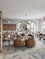Un salón moderno con un ventanal grande, una alfombra estampada y un sofá con otomanas.