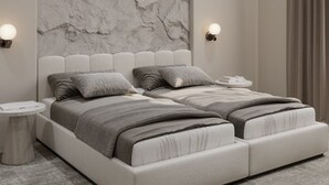 A modern bedroom with a marble headboard, two beds, bedside tables, and an air conditioning unit. - Dastan Baku Hotel (Baku)