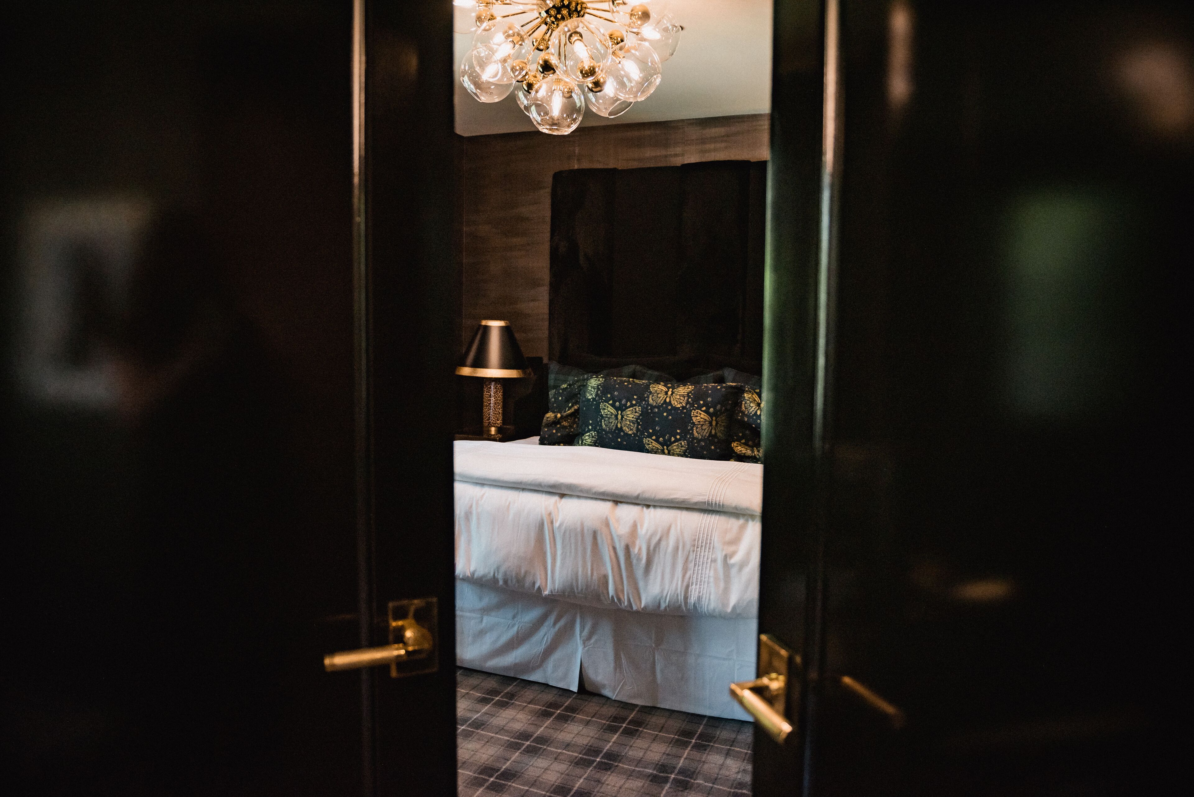 Un dormitorio con cama, lámpara y candelabro.