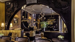 A luxurious interior with a grand arched doorway, elegant chandeliers, and a piano. - The Scotsman Hotel (Niagara-on-the-Lake)