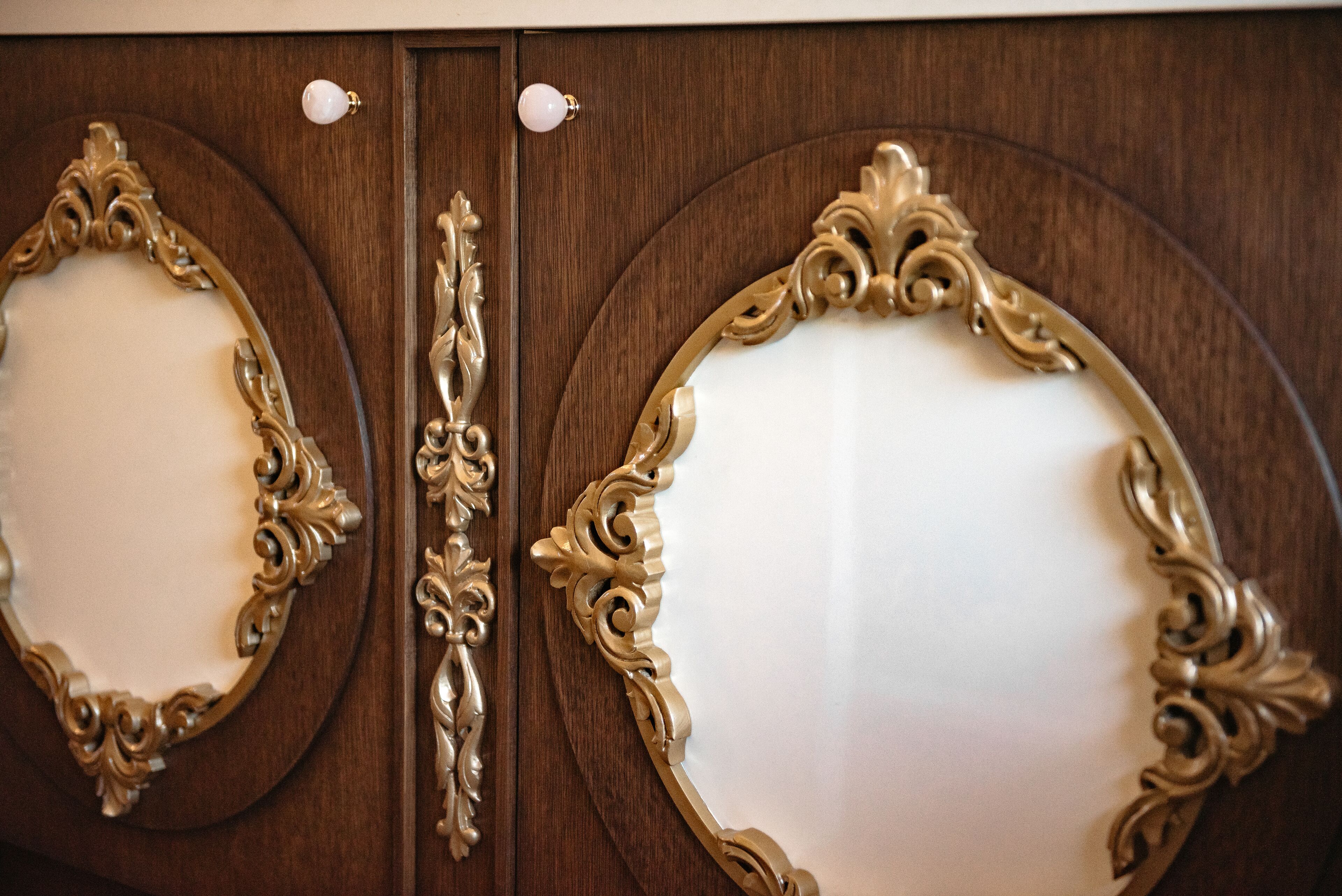 Dos espejos ornamentados con diseños intrincados en una puerta de madera.