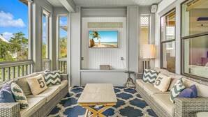 A coastal living room with wicker furniture, a beach-themed TV, and a 'FLIP FLOP LIFE' sign. - 30A ~ 3 Primary Suites ~ Next to Community Pool (Inlet Beach)