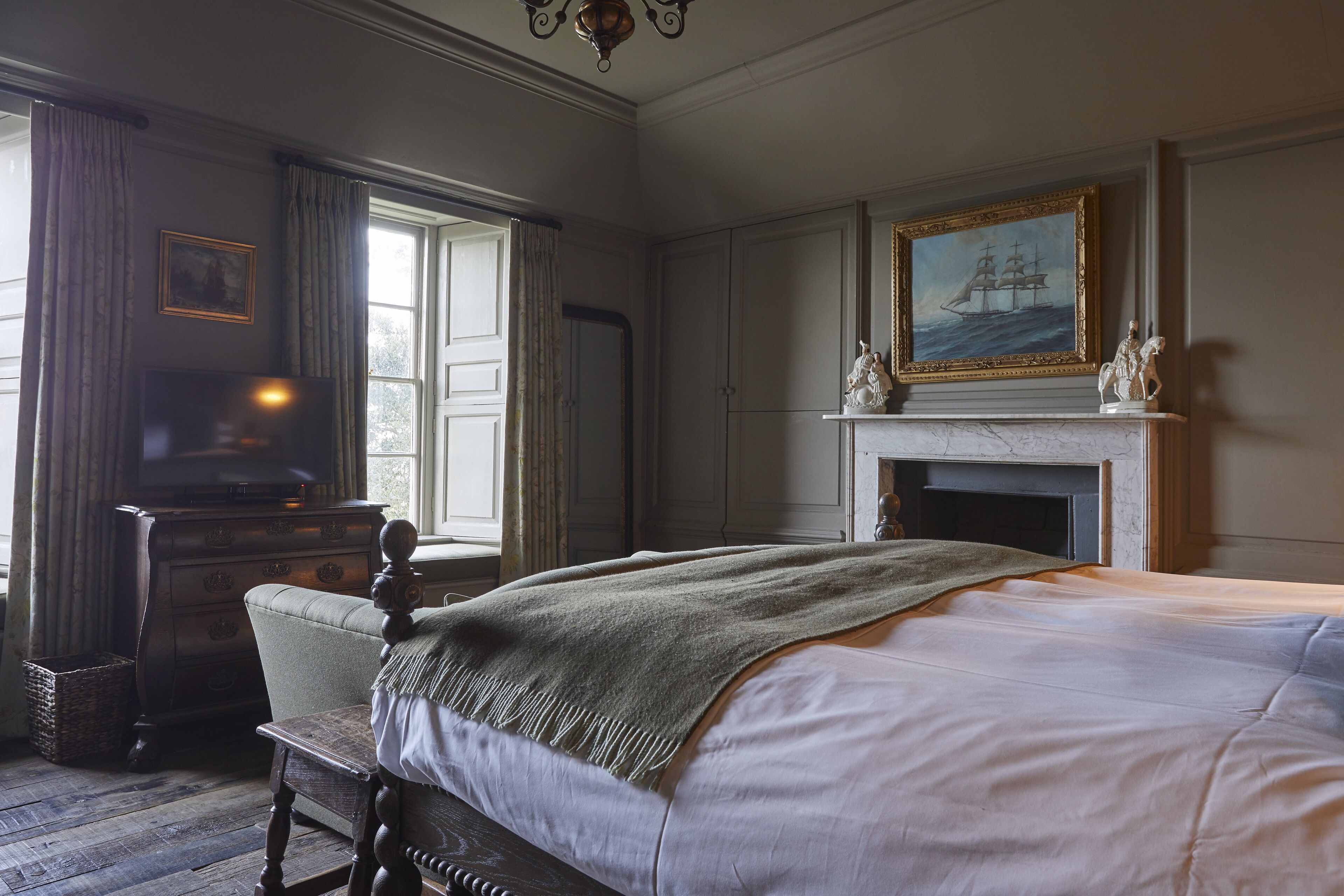 Une chambre à coucher de style traditionnel, avec un lit, une commode et une cheminée.
