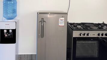 Une cuisine équipée d’un réfrigérateur en acier inoxydable, d’un distributeur d’eau et d’une cuisinière à gaz.