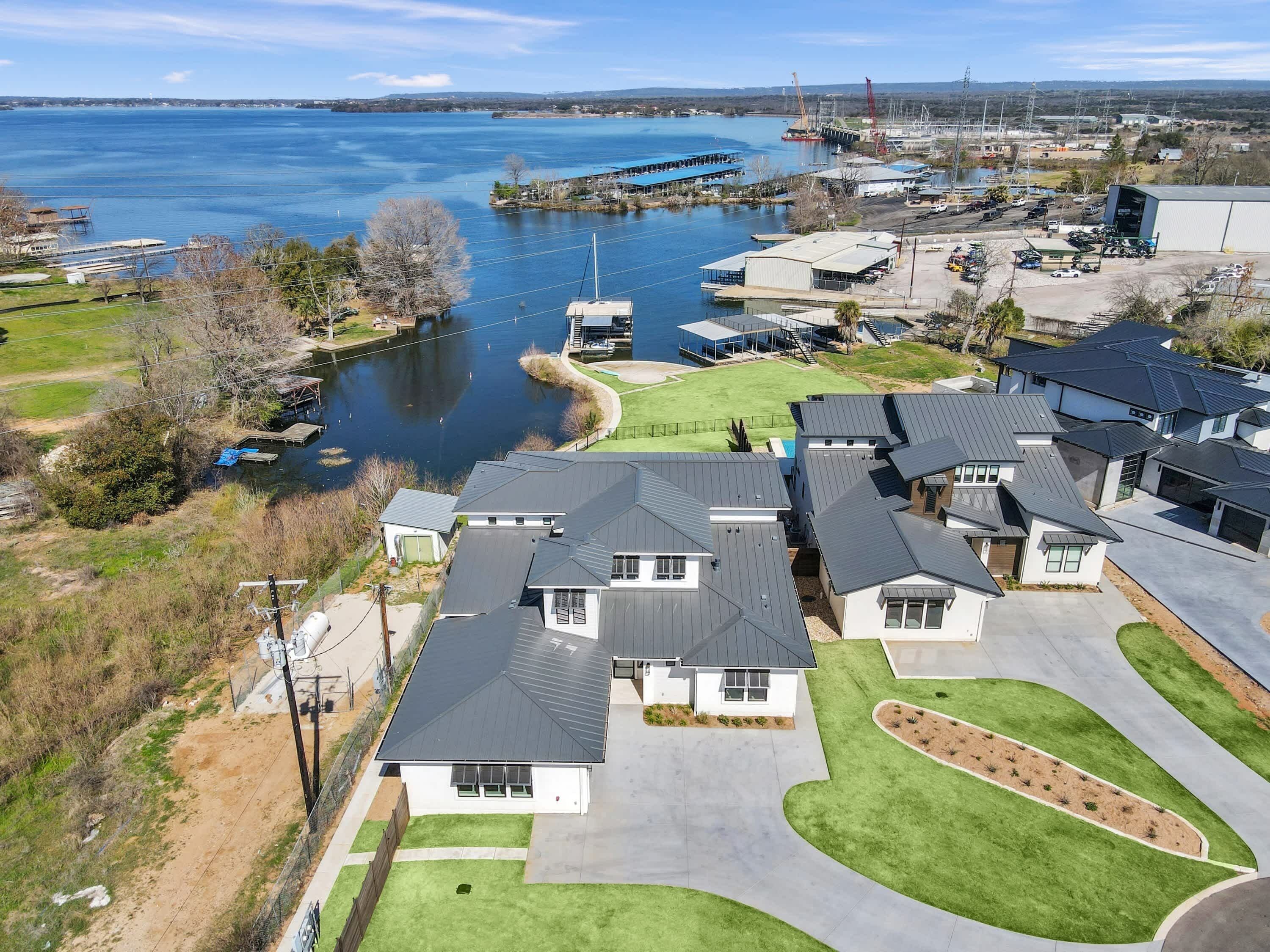 A residential area with houses, a dock, and a large body of water.