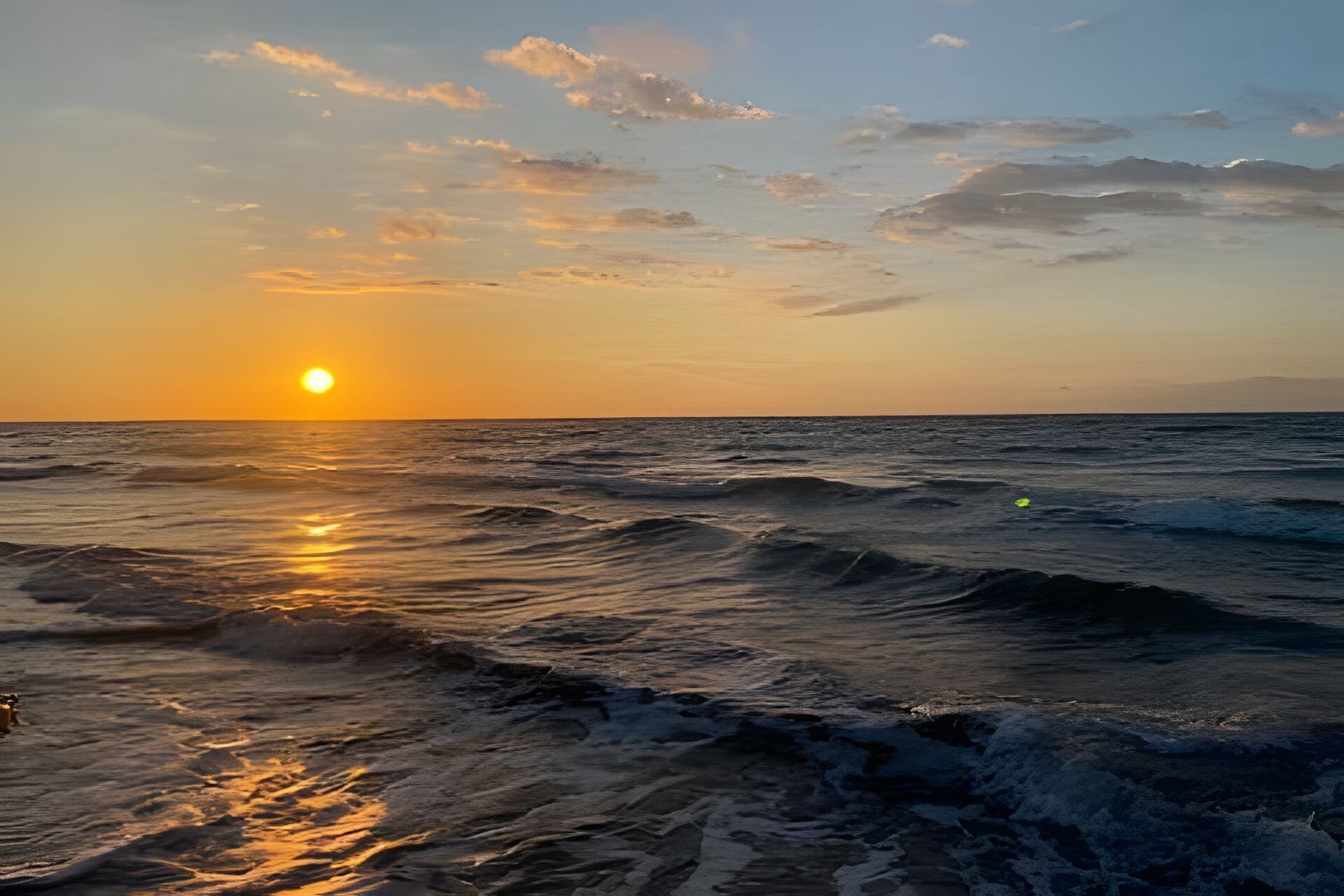 Atardecer sobre el océano con olas.