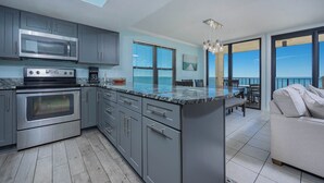 Una cocina moderna con gabinetes grises, electrodomésticos de acero inoxidable y una isla grande.